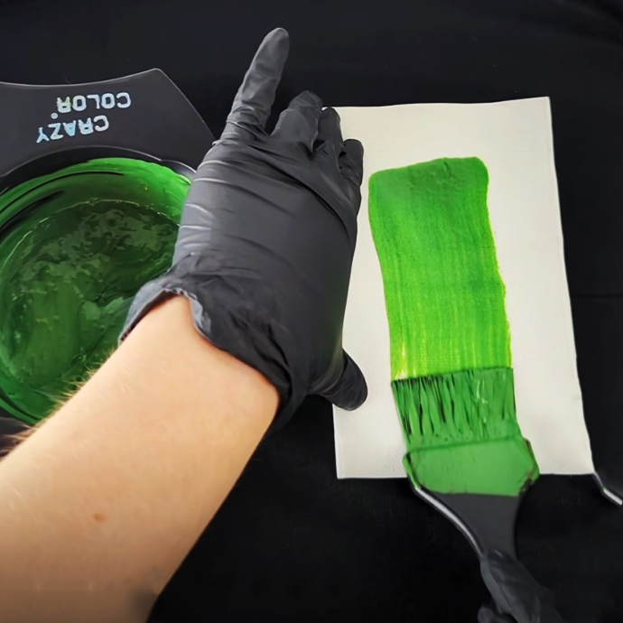 image of woman using crazy color bowl and brush to mix bright green hair dye