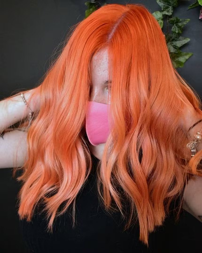 user generated close up image of woman with pastel orange wavy shoulder length hair
