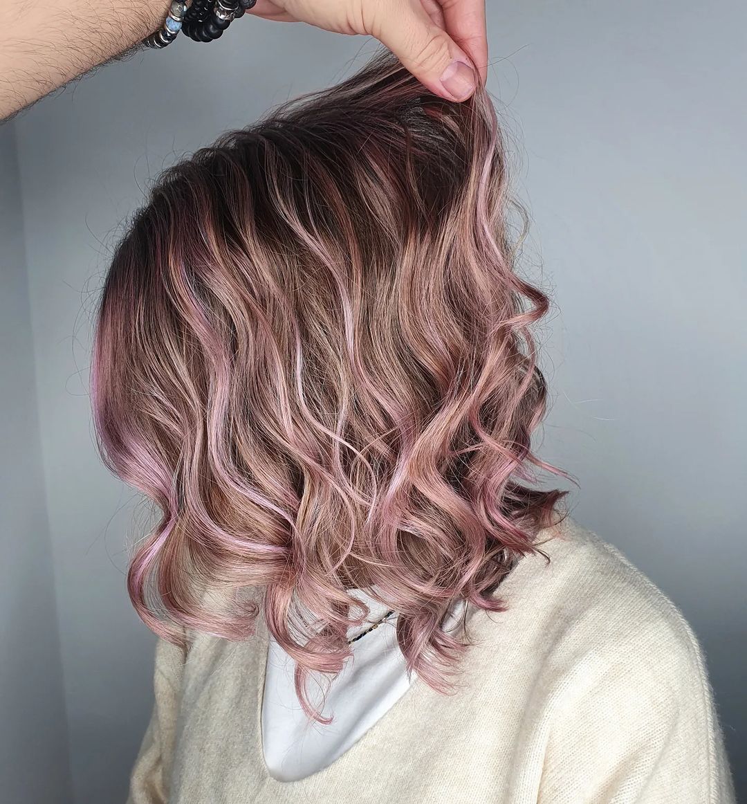 image of hand holding woman's metallic purple short curly hair